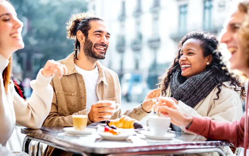 Four friends laughing at a coffeeshop